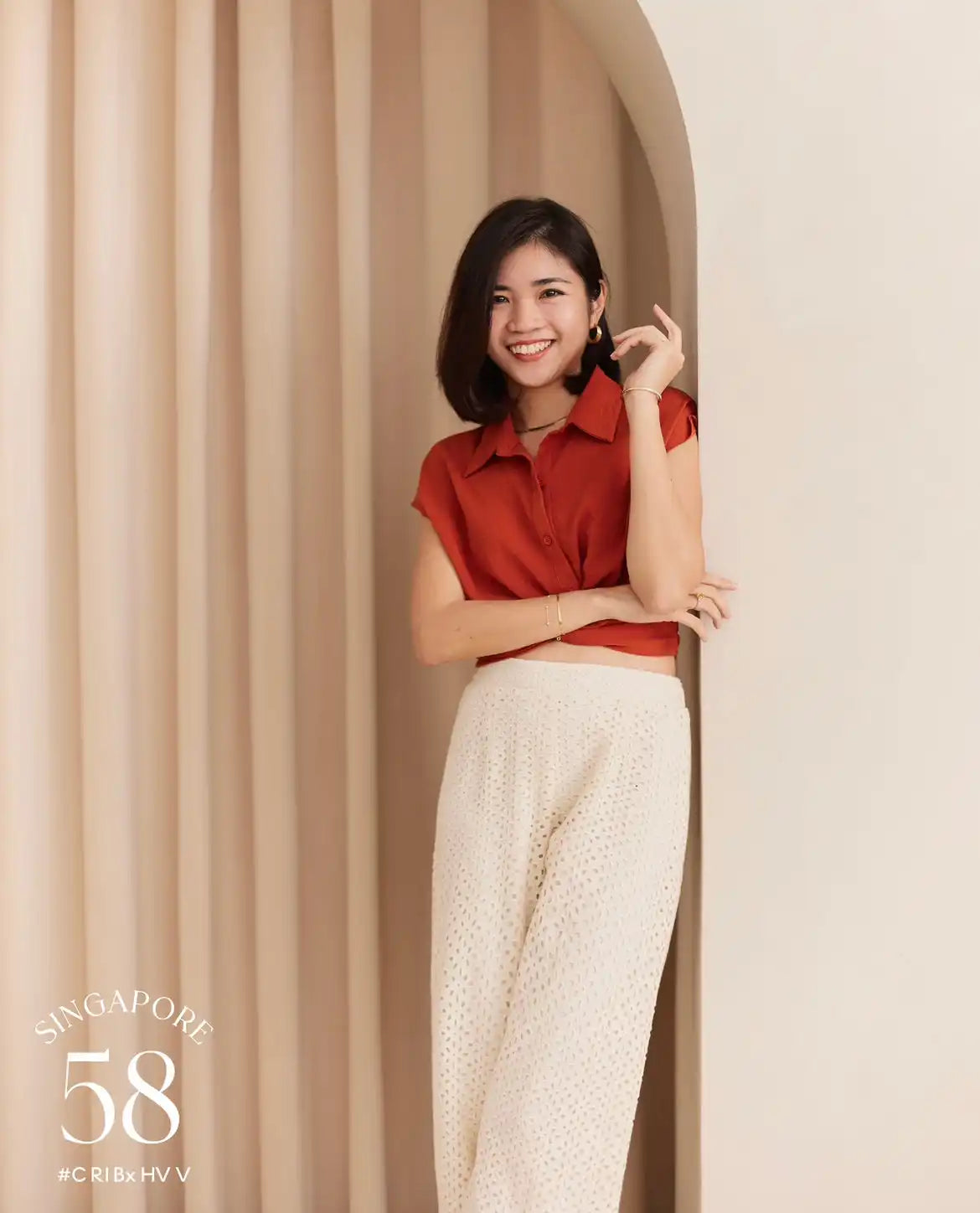 Smiling woman in red top and white pants.