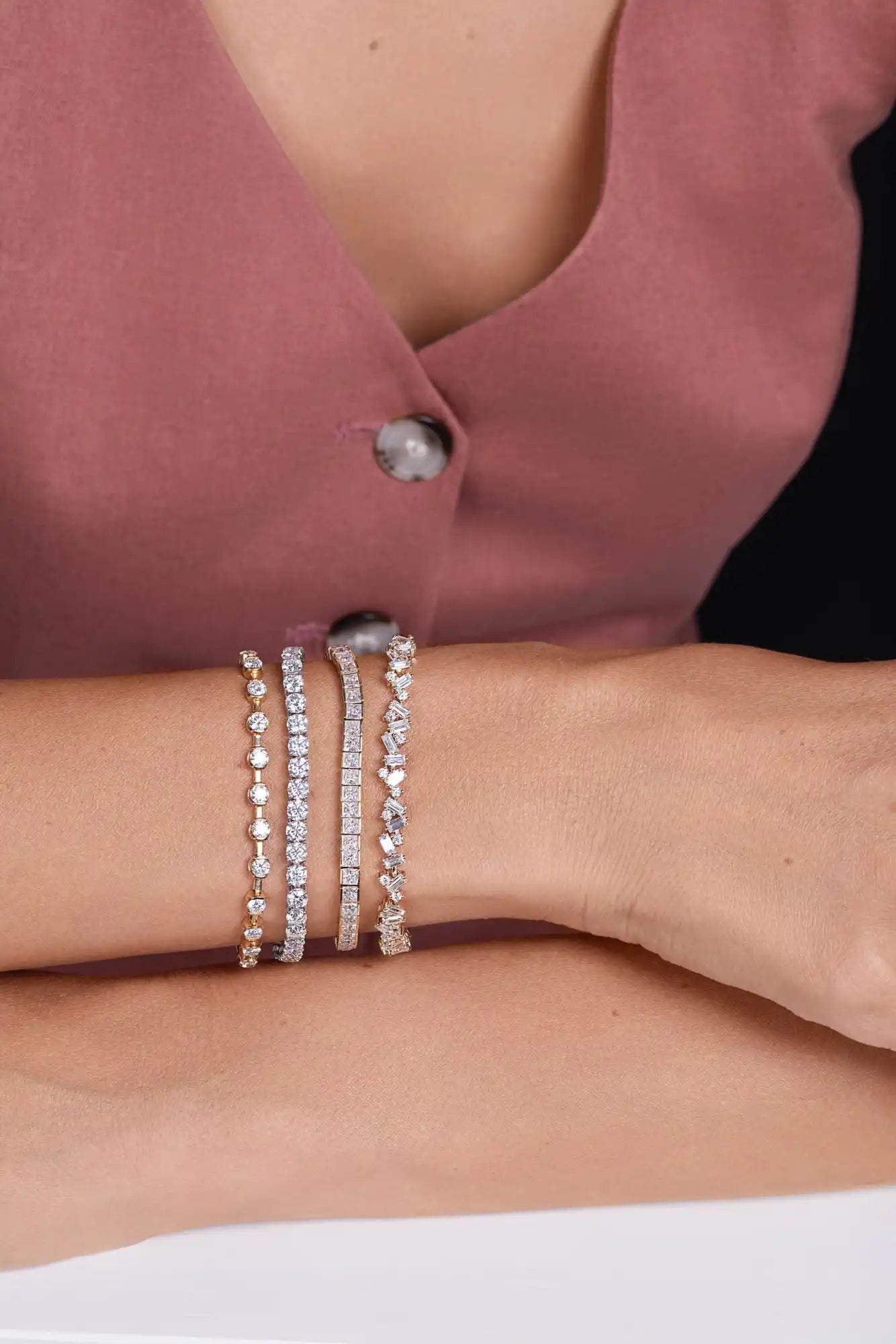 Wrist adorned with four delicate, sparkling bracelets.